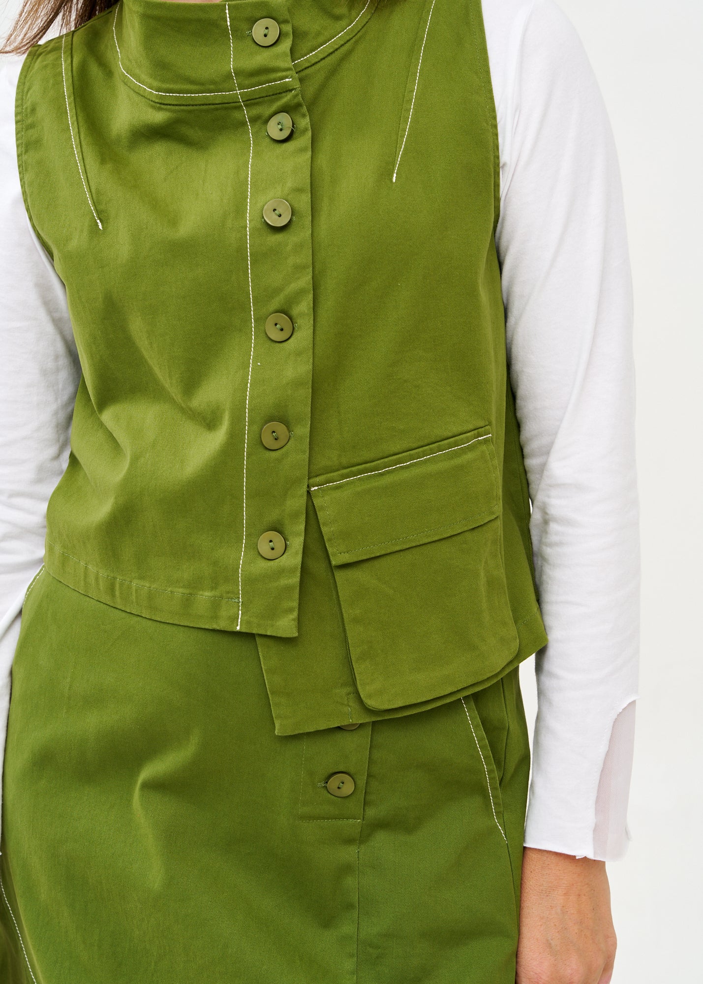 Green asymmetrical vest with prominent stitching