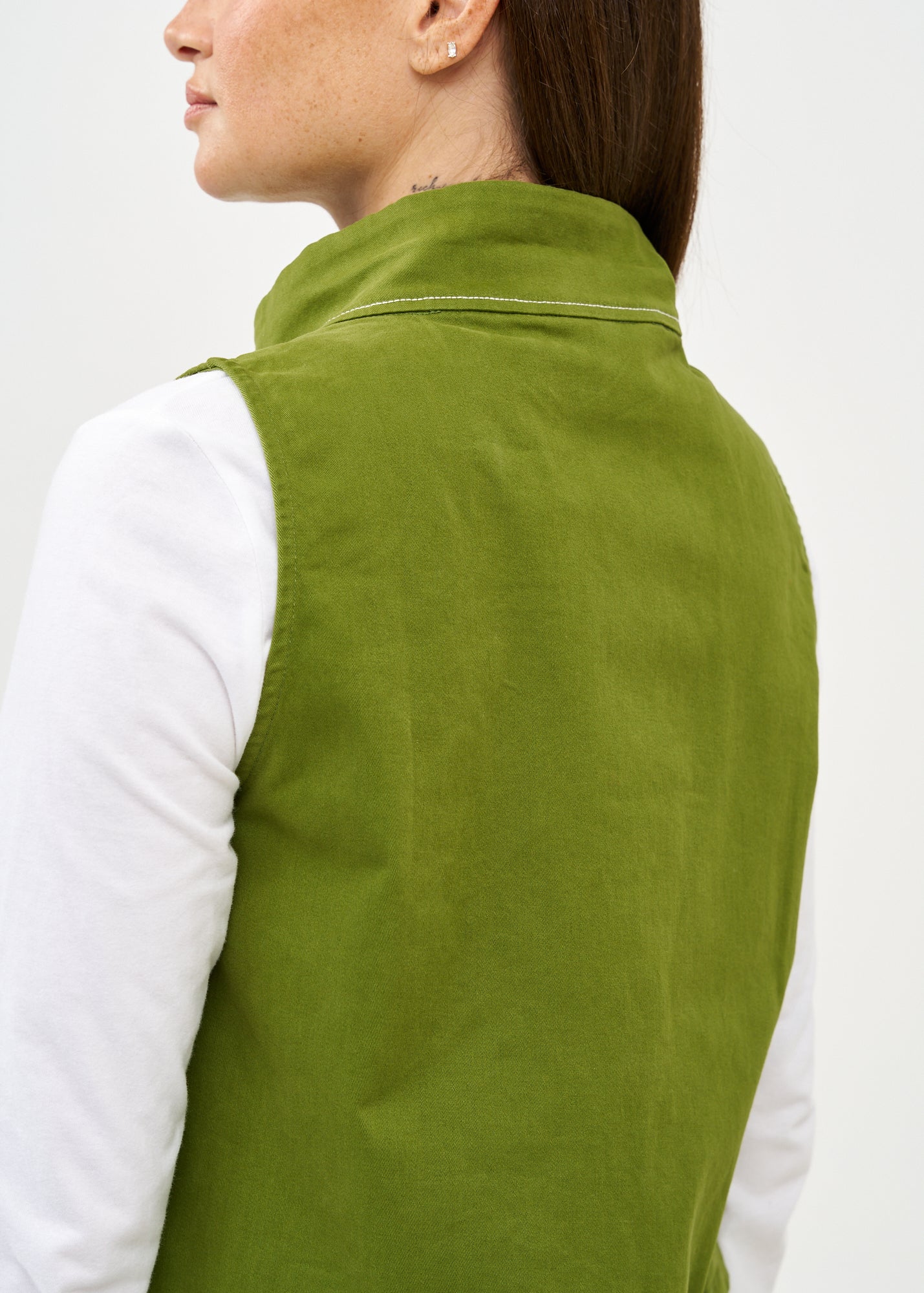 Green asymmetrical vest with prominent stitching