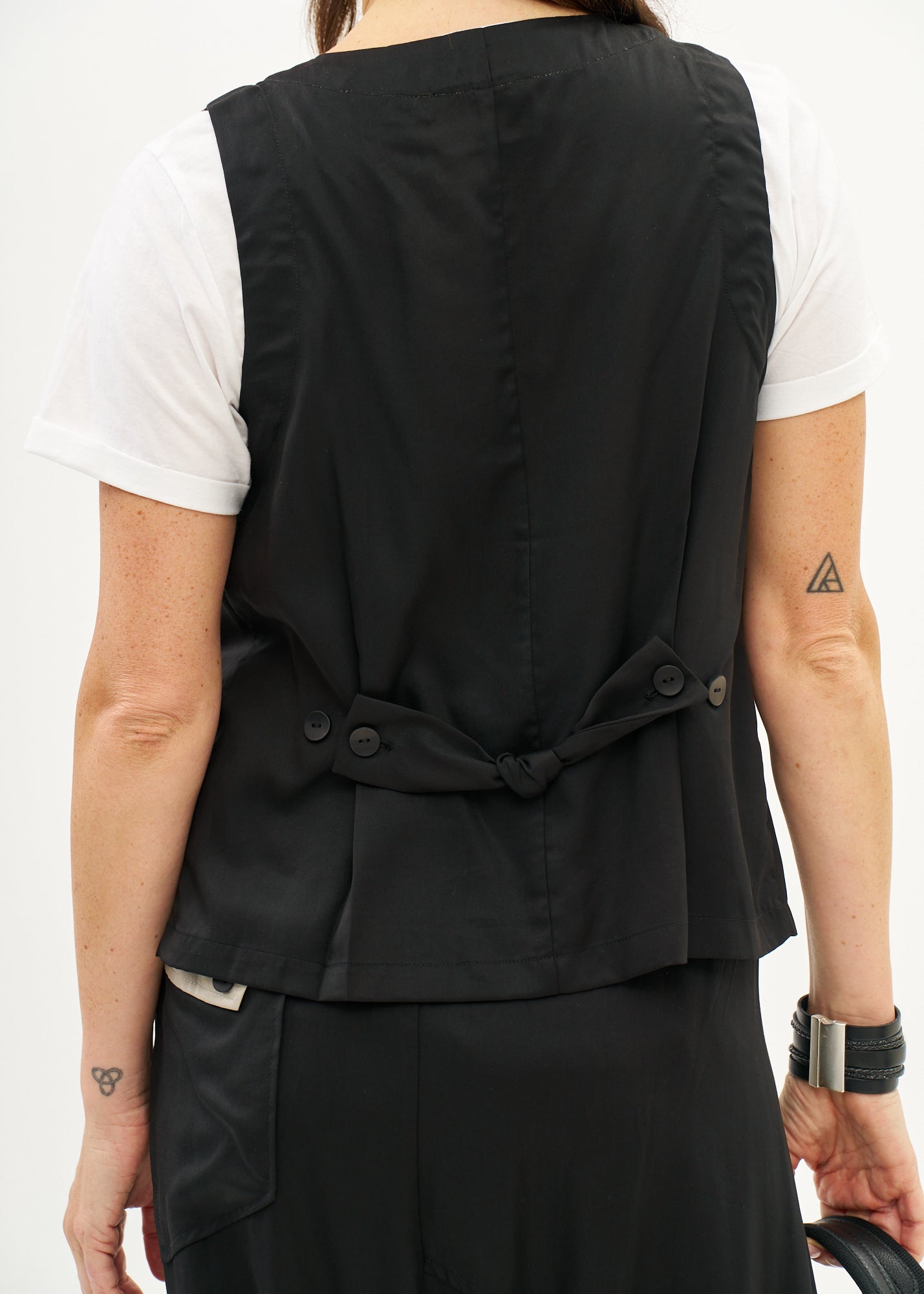 Vest with slanted pockets and a tie-back in black