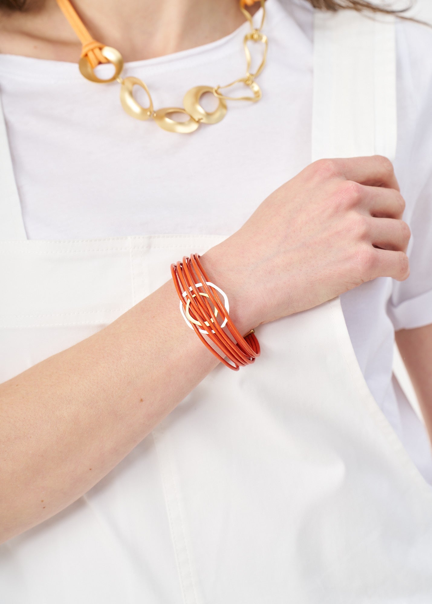 Bracelet with thin leather cords and two asymmetrical orange circles