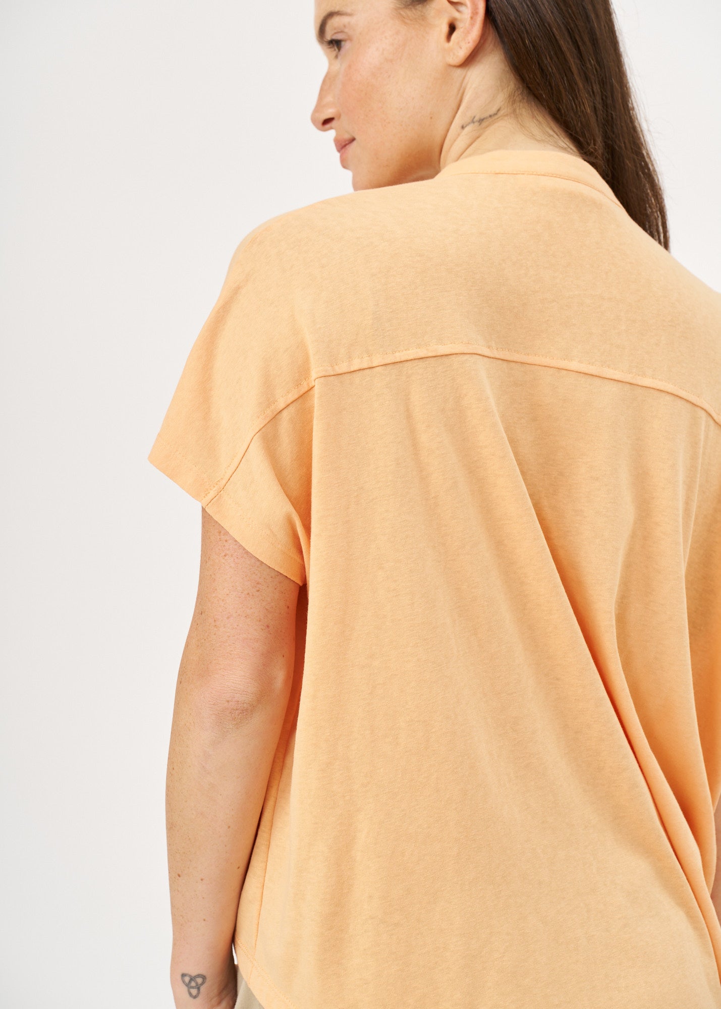 Shirt with buttons and a twisted orange extension