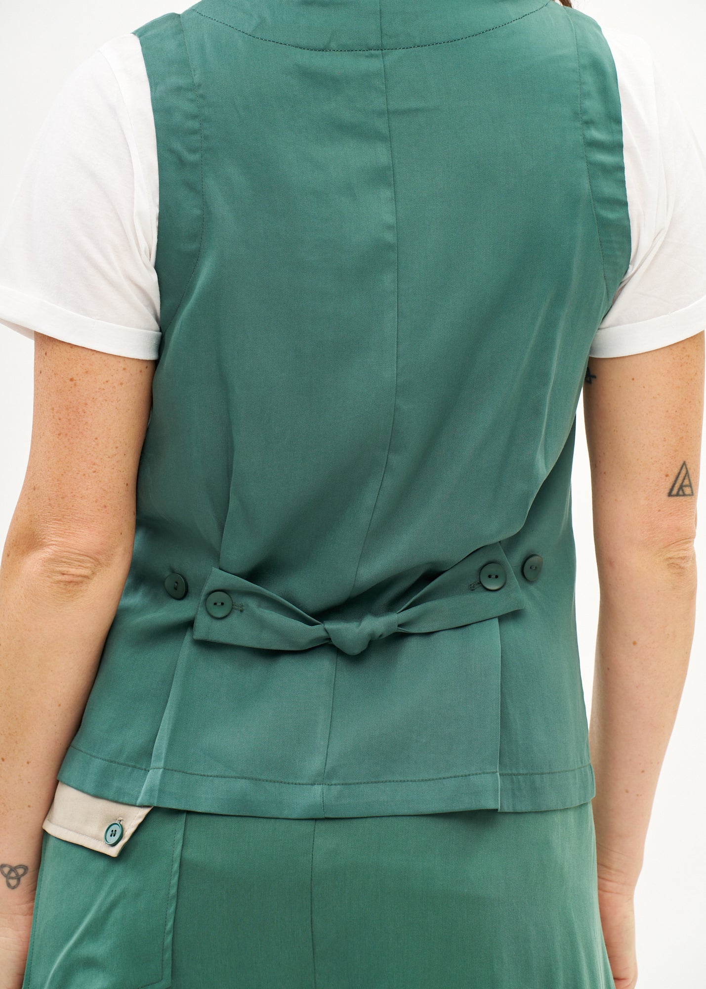 Green vest with angled pockets and tie-back
